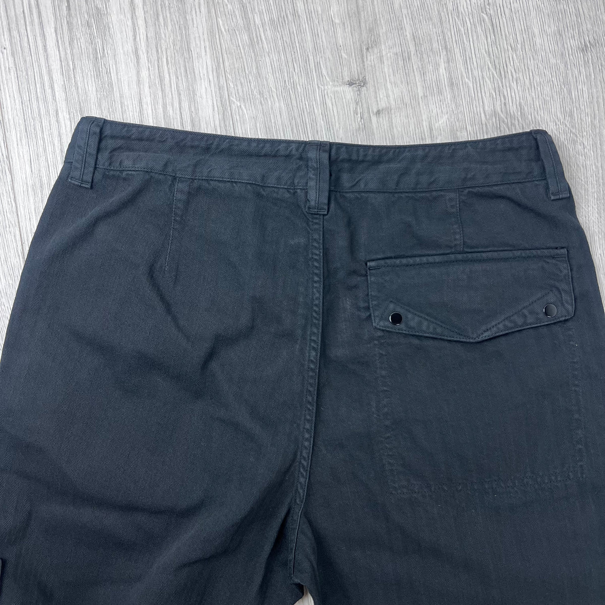 Rear view of the waistband and back patch pocket on the Stone Island Cotton Herringbone Chino Trousers in Black.