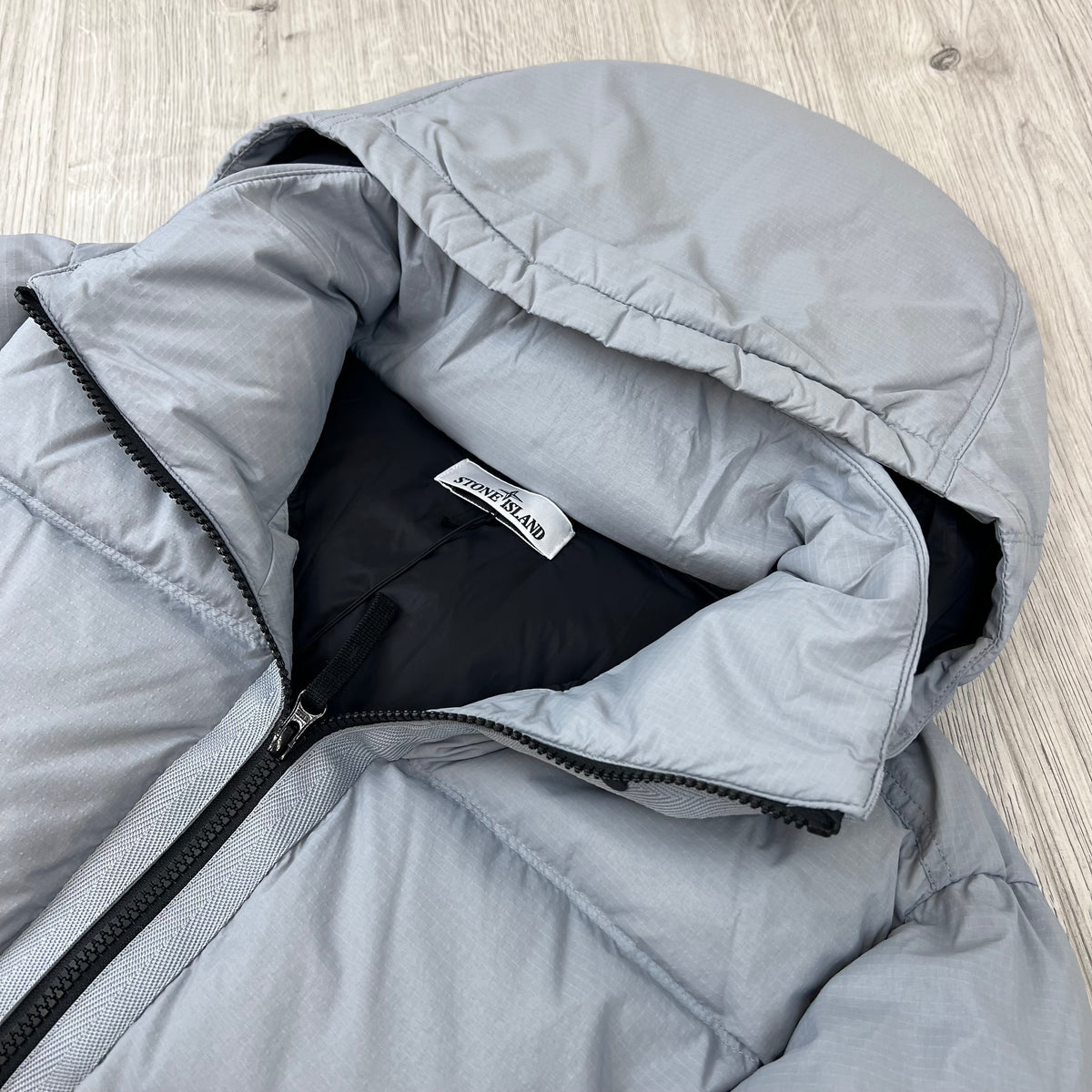 A close up angled view of the collar Stone Island Matt Ripstop CORDURA® Down Jacket in Ash Grey.