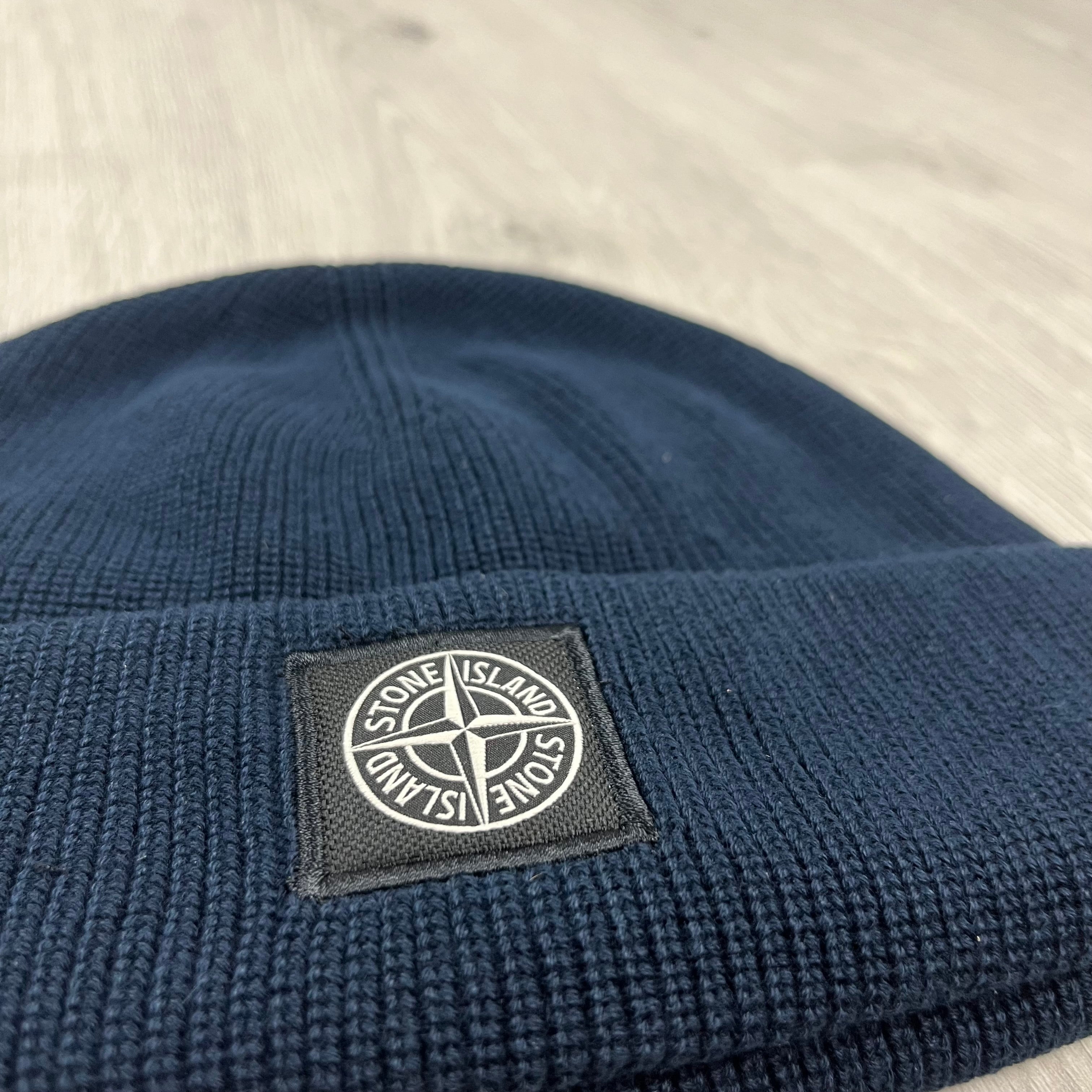 Men's Stone Island beanie with a compass patch logo on the front. On sale at Open Attire.