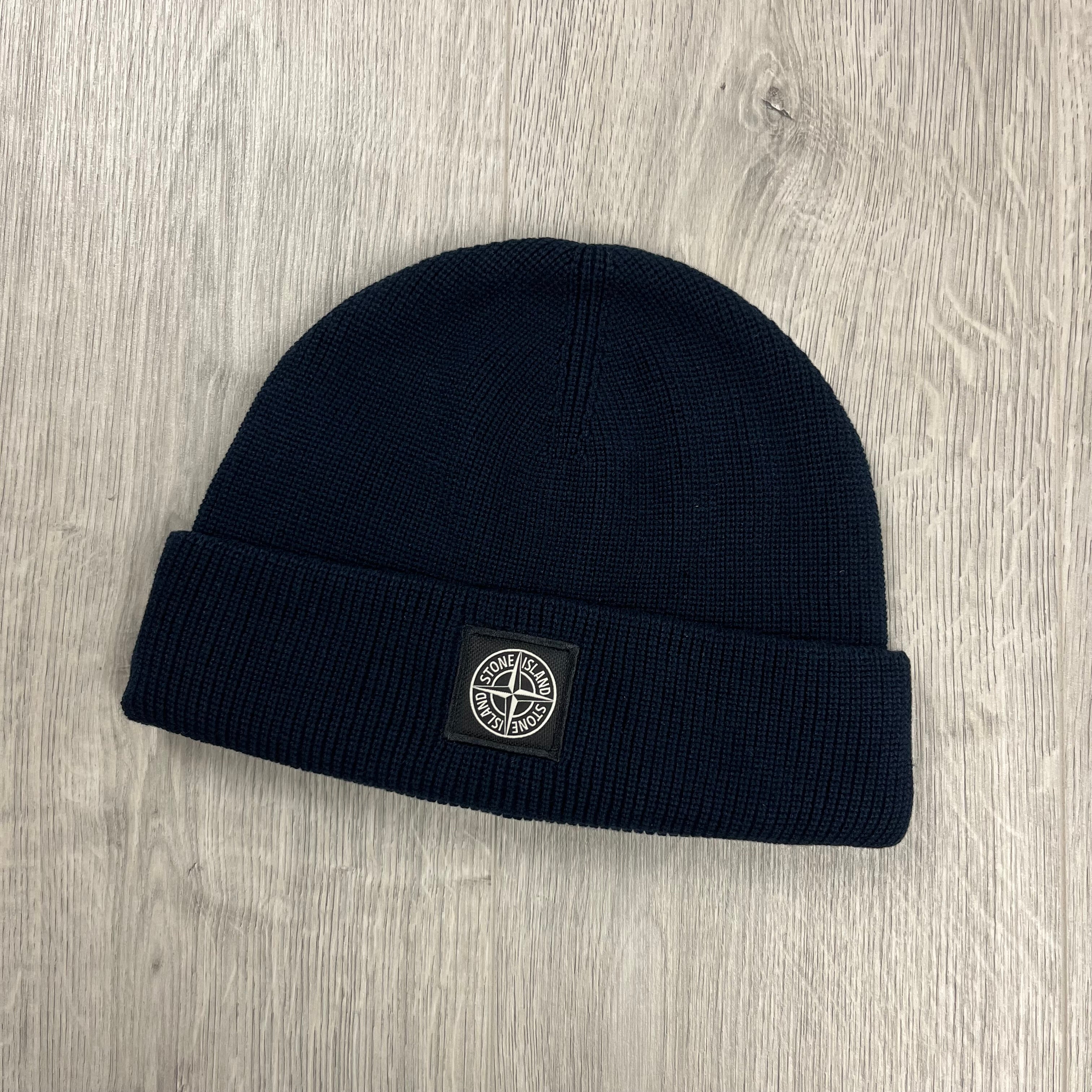 Men's Stone Island beanie with a flat ribbed cuff and compass patch logo on the front. On sale at Open Attire.