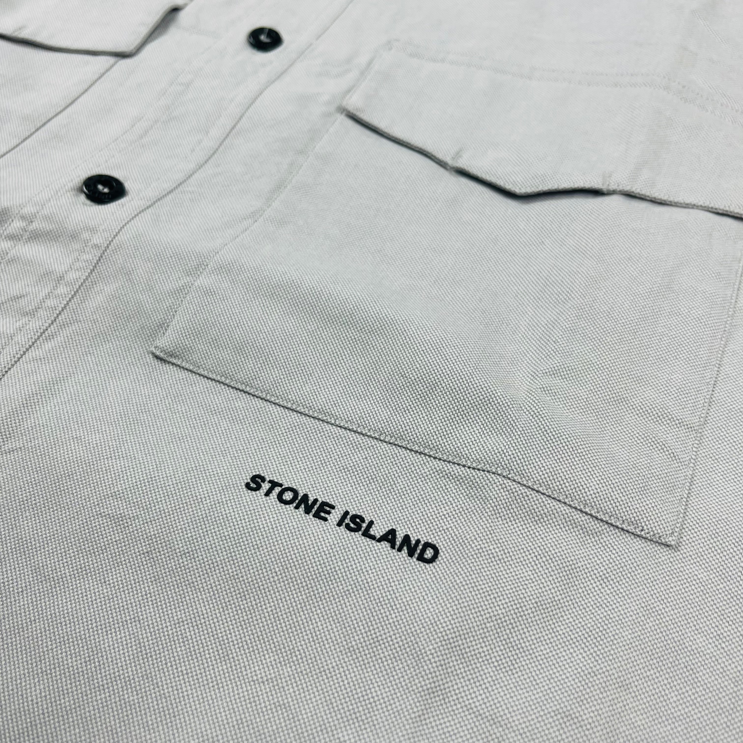 Men's Stone Island Button Shirt with a midriff logo. On sale at Open Attire.