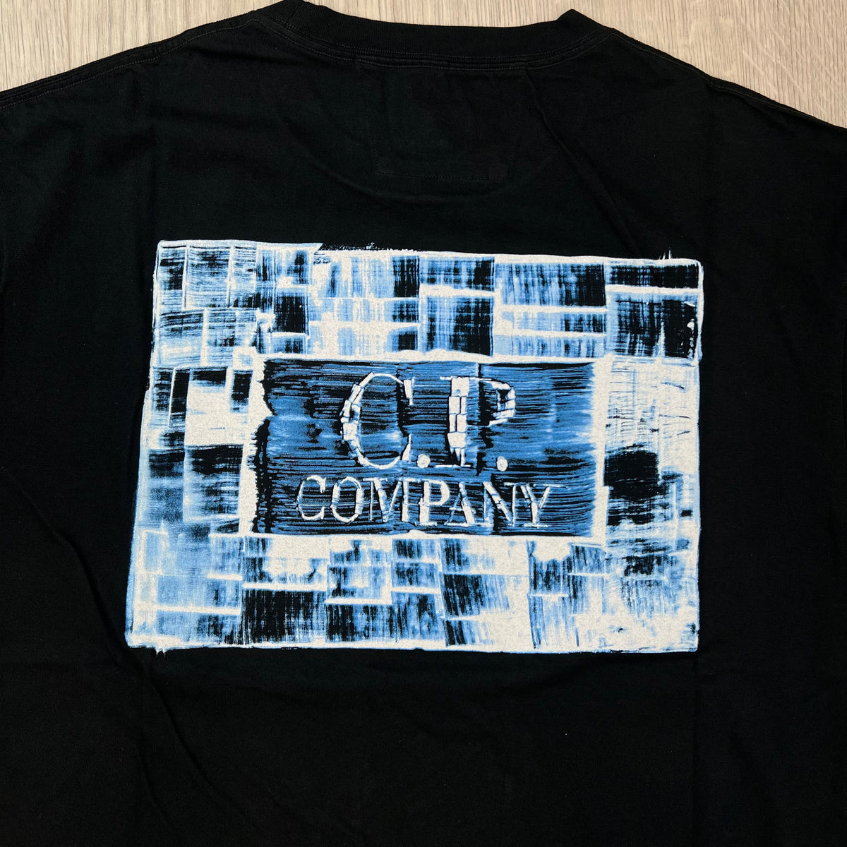 Rear view of the large printed logo on  CP Company 30/1 Jersey Graphics T-Shirt in Black. 