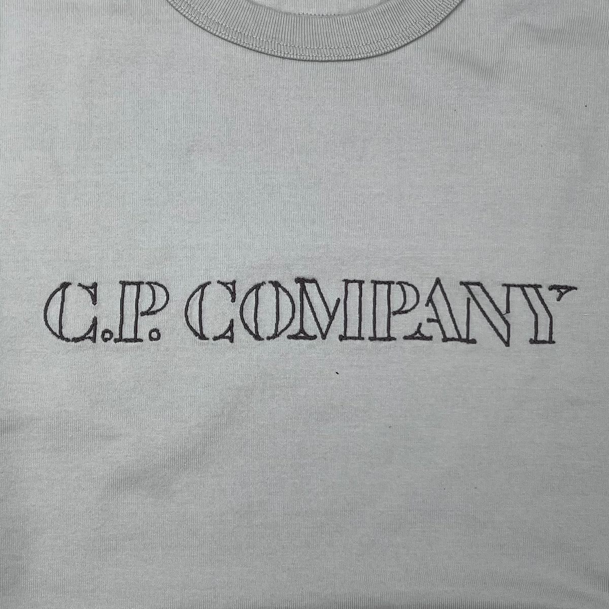Close up view of the embroidered stencil on a CP Company 30/2 Jersey Logo T-Shirt in Silver Birch. 