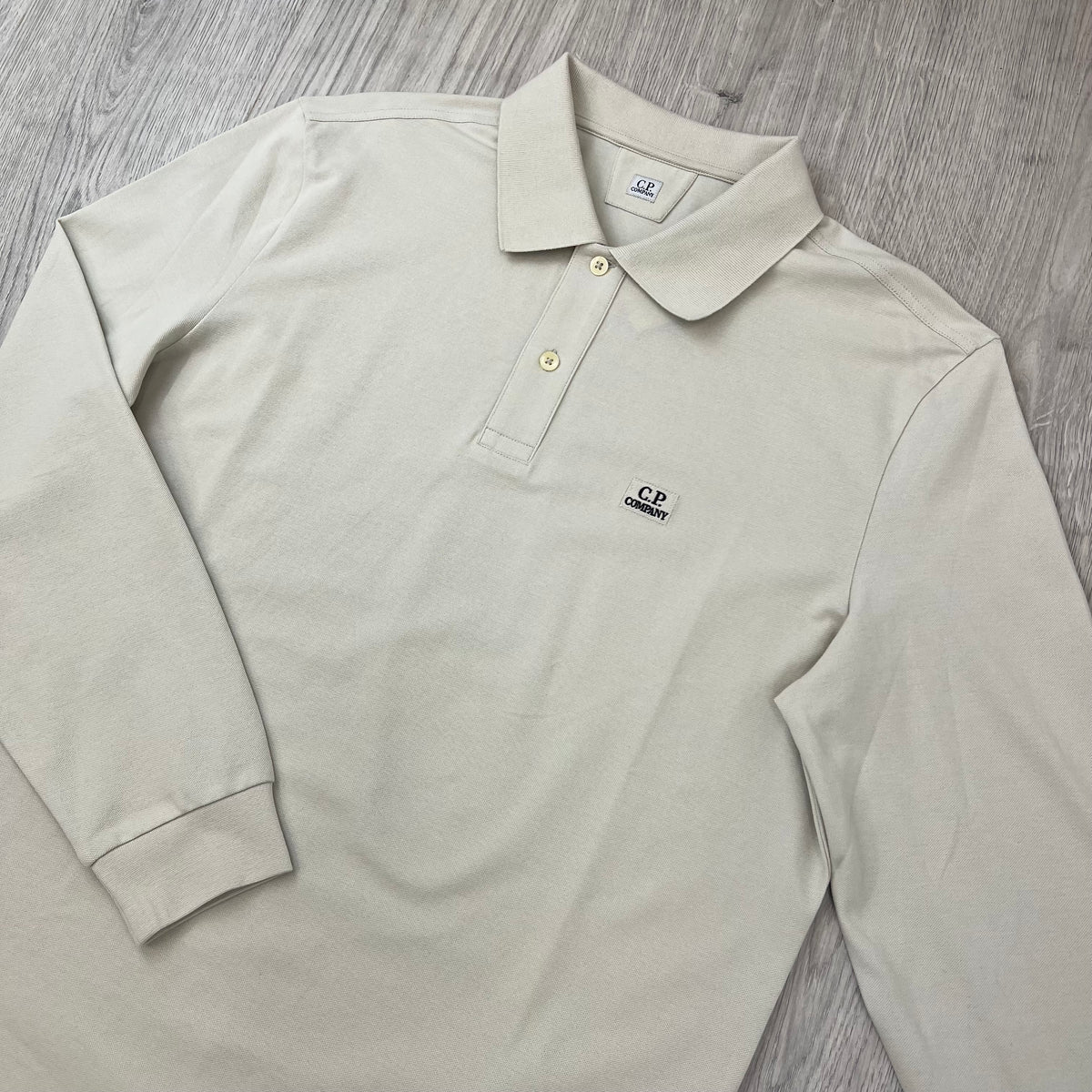 Angled view of the CP Company Long Sleeve Stretch Piquet Polo Shirt in Silver Birch.
