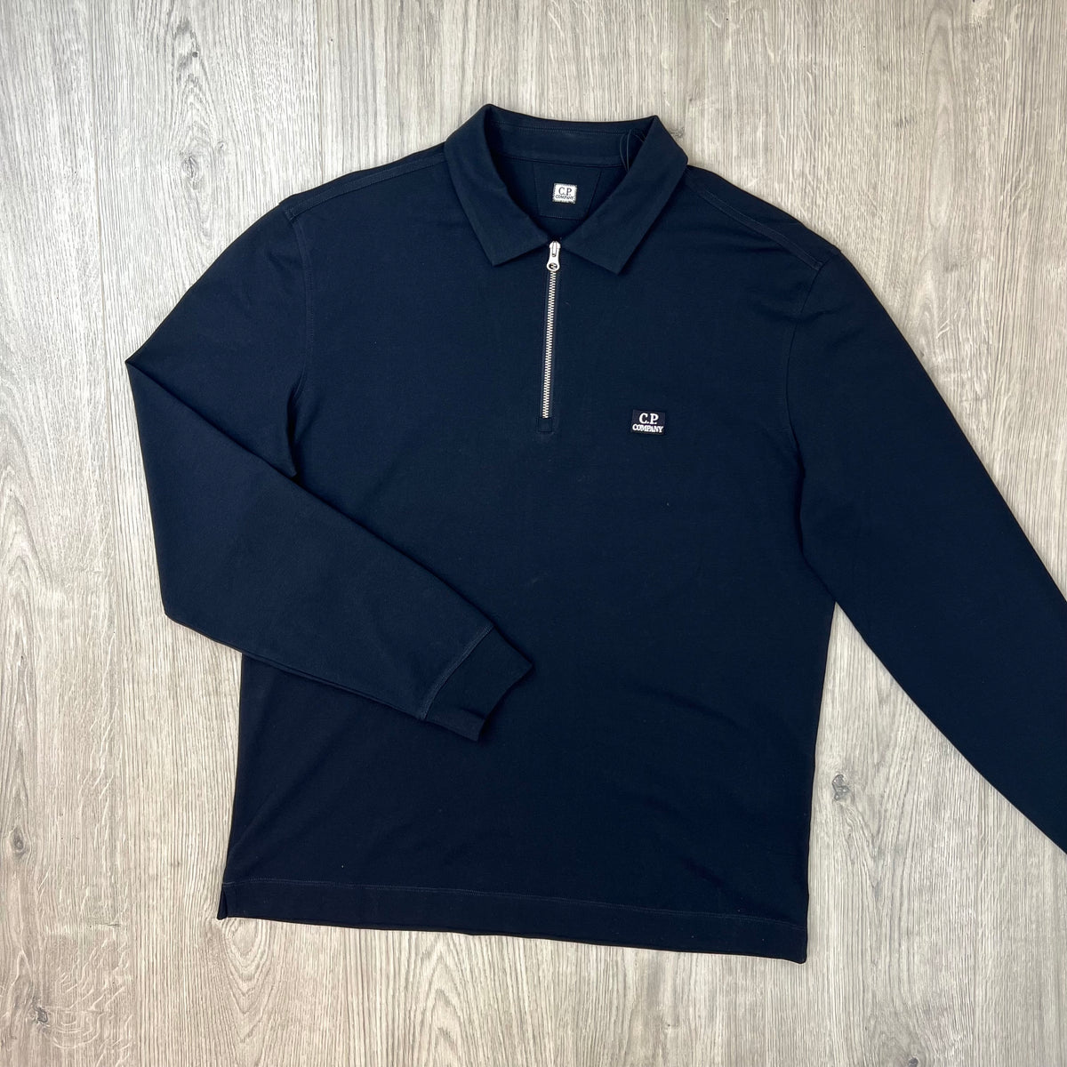 Front view of a CP Company Stretch Piquet Long Sleeve Polo Shirt in Navy Blue. 