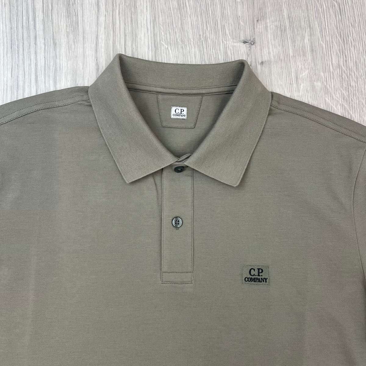 Close up view of the polo collar and two-button placket on a CP Company Stretch Piquet Polo Shirt in Fallen Rock.