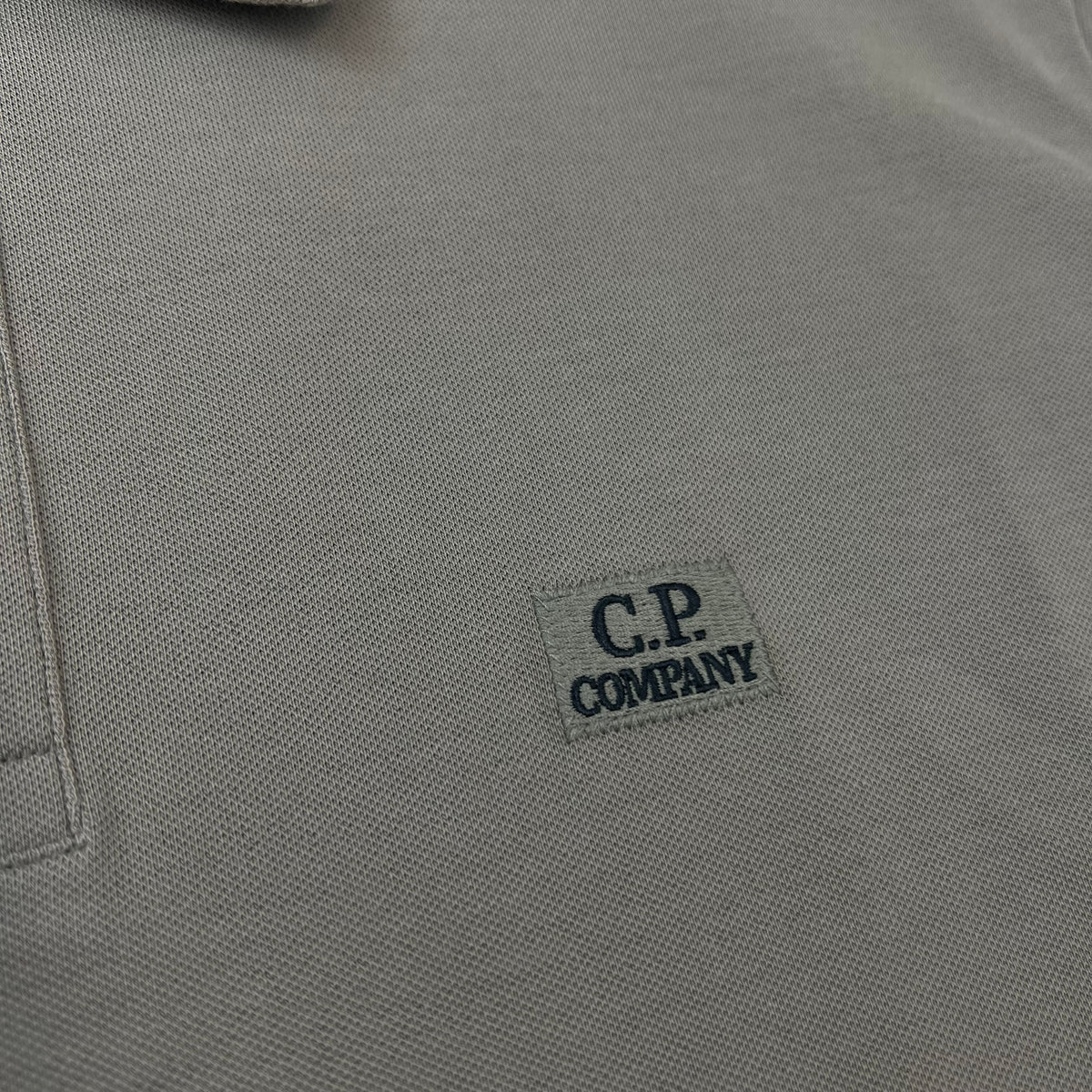 Close up view of the embroidered logo patch on a CP Company Stretch Piquet Polo Shirt in Fallen Rock.