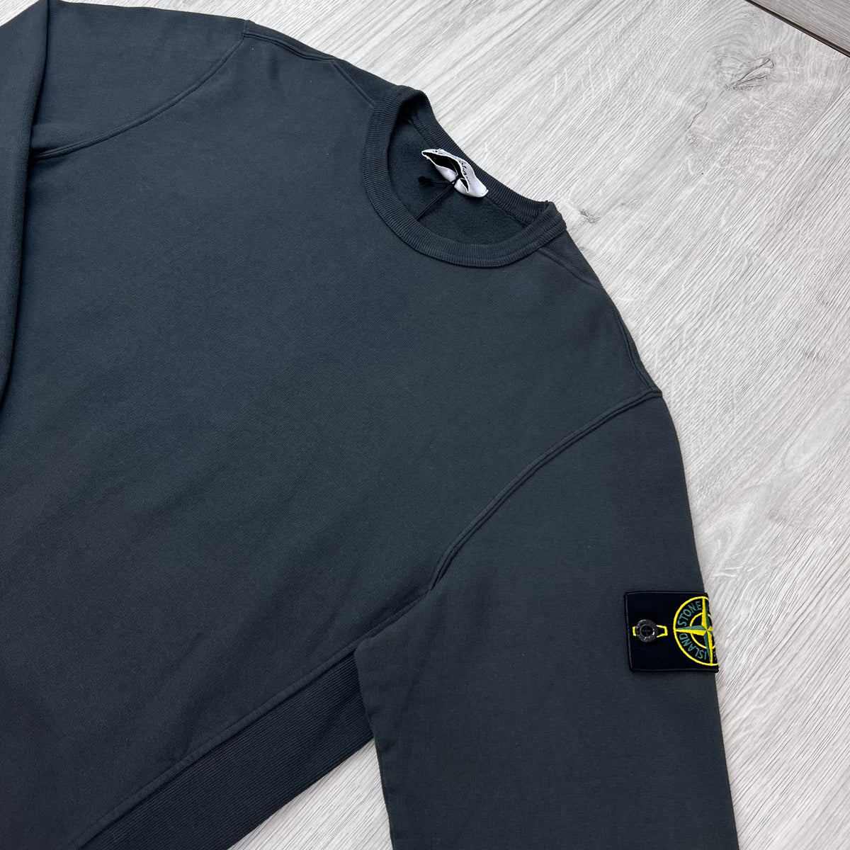Angled view of the Stone Island Crewneck Brushed Cotton Sweatshirt in Lead Grey.