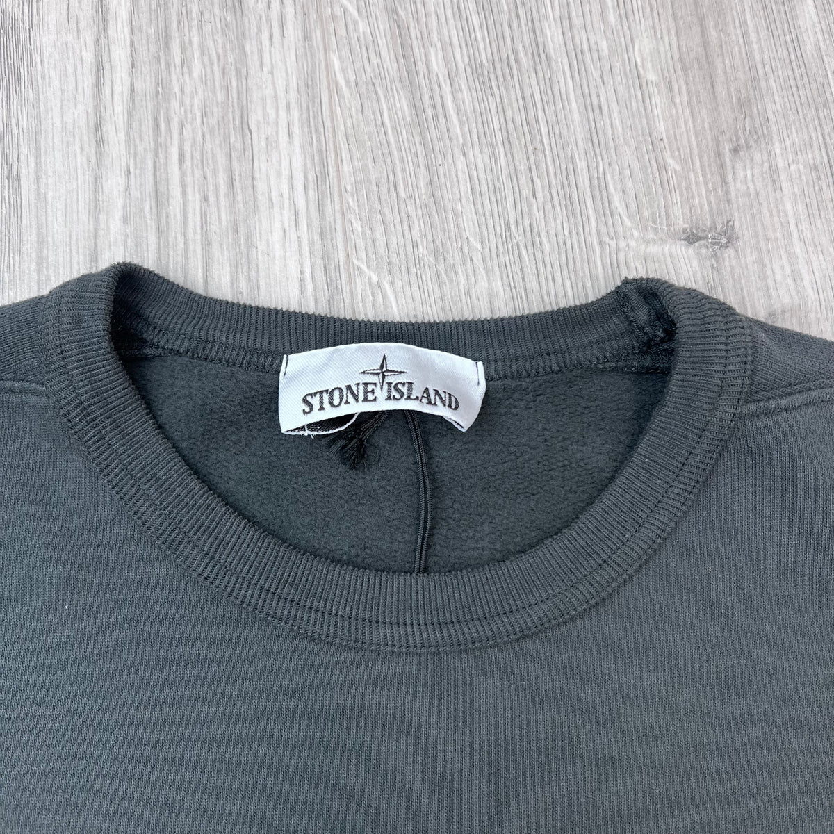 A close up view of the crewneck collar on a Stone Island Crewneck Brushed Cotton Sweatshirt in Lead Grey.