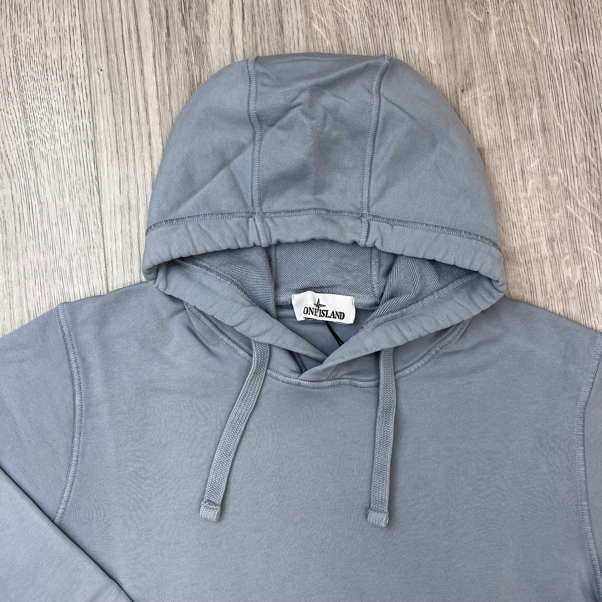 A close up view of the hood and drawstring on a Stone Island Pullover Hoodie in Ash Grey. 