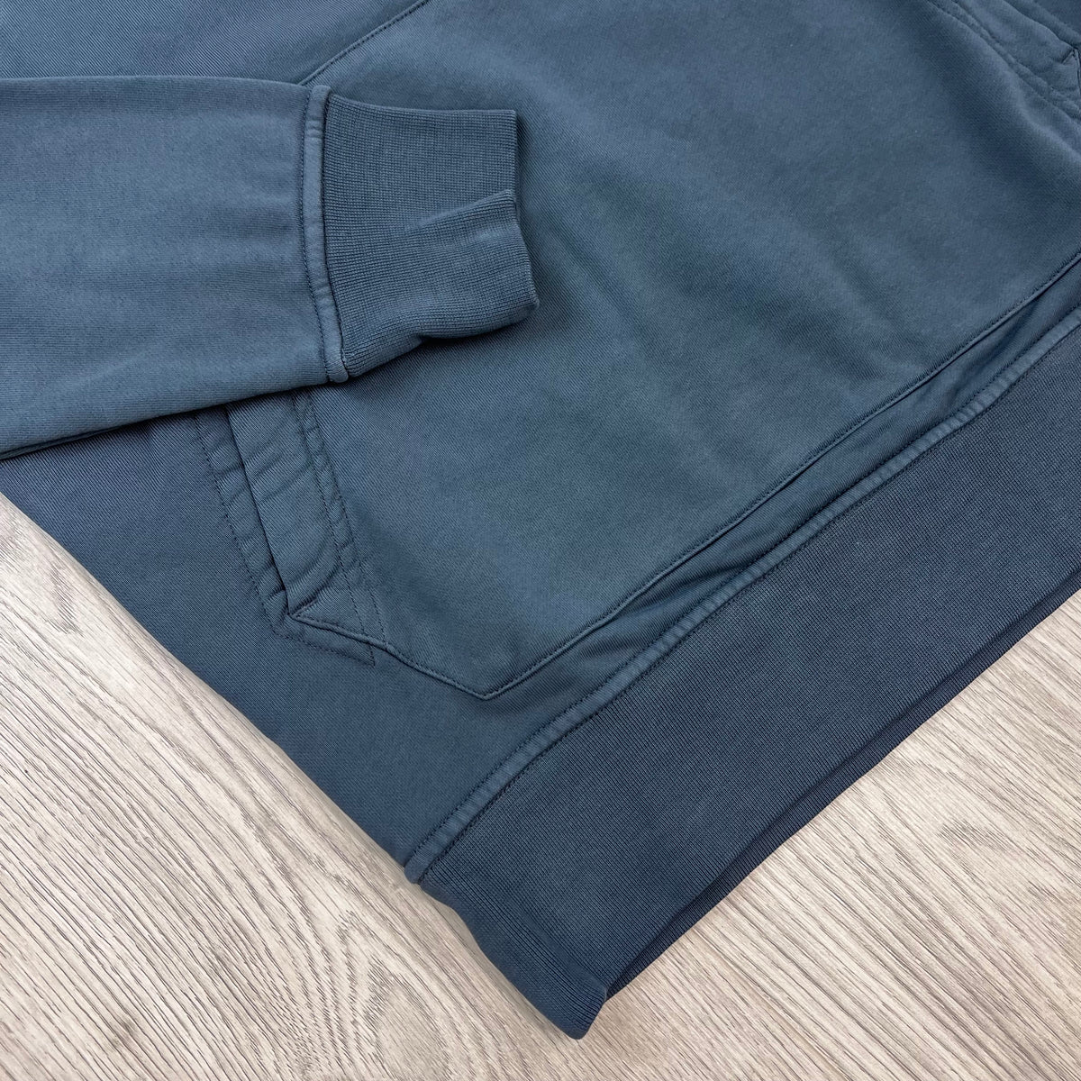 A close view of the elasticated hem and cuff on a Stone Island Pullover Hoodie in Slate Blue. 