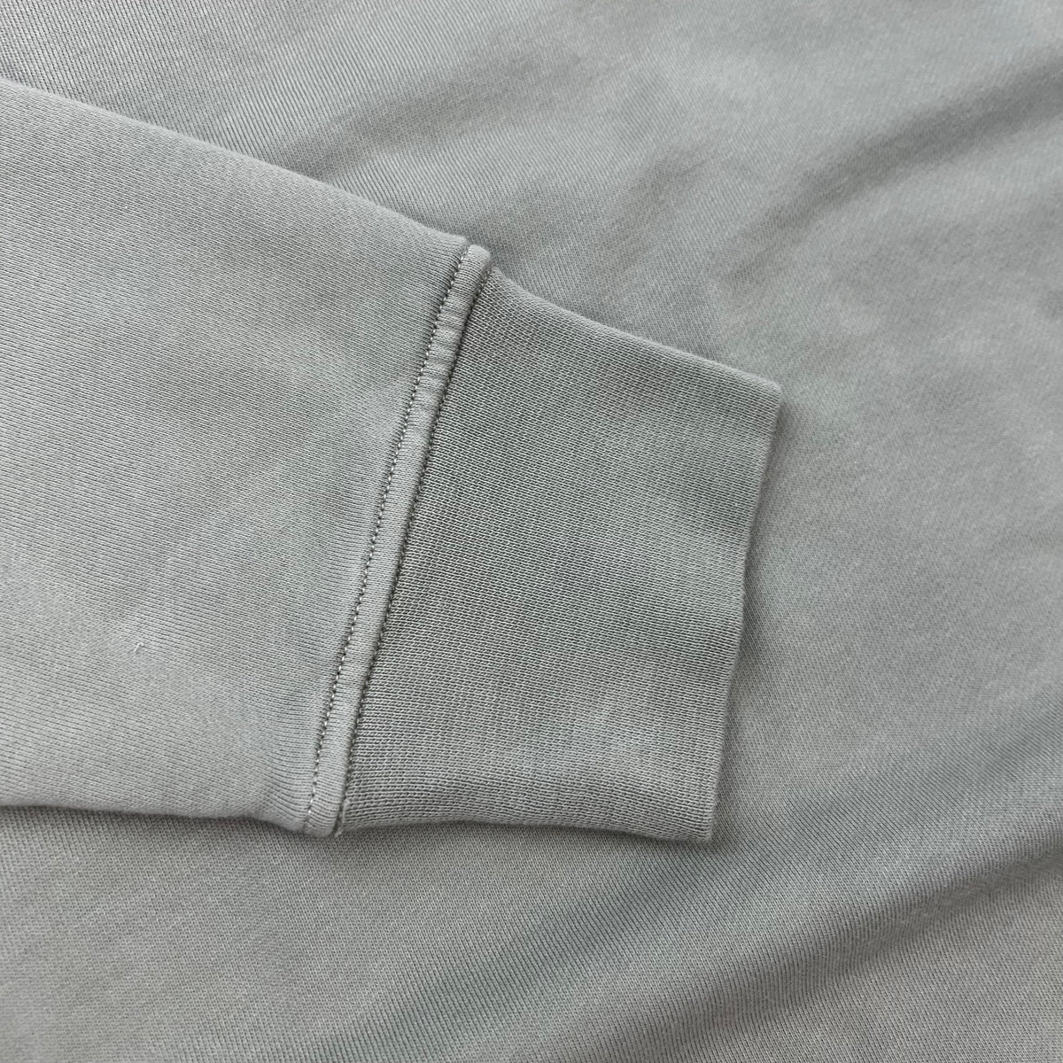 A close up view of the cuffs on a Stone Island Crewneck Sweatshirt in Laurel Green.